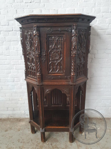 картинка Антикварный поставец в готическом стиле с барельефами и латунными накладками салоне старинных вещей "Шебби" являющийся официальным дистрибьютором в России и Беларуси