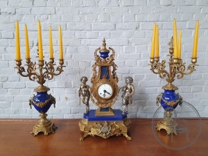 картинка Старинные каминные часы, с канделябрами, декорированные скульптурами путти салоне старинных вещей "Шебби" являющийся официальным дистрибьютором в России и Беларуси