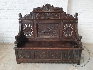 картинка Антикварная скамья с насыщенной резьбой в мифологической тематике салоне старинных вещей "Шебби" являющийся официальным дистрибьютором в России и Беларуси